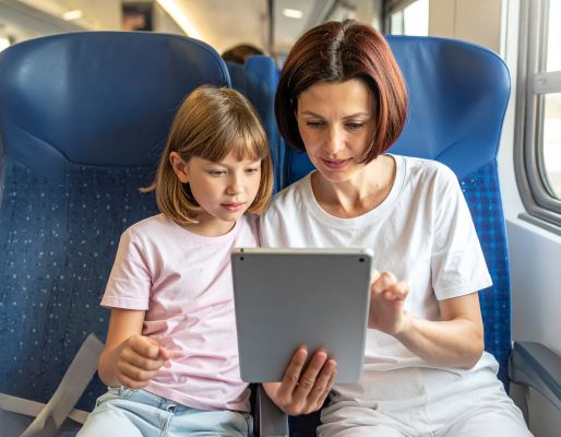 Happy parents and child reading a personalized digital storybook together on a tablet.