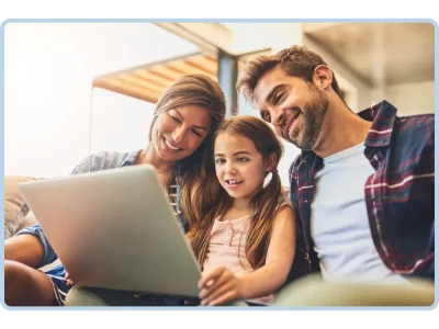 Eine glückliche Familie erstellt gemeinsam ein personalisiertes Buch auf dem Laptop.